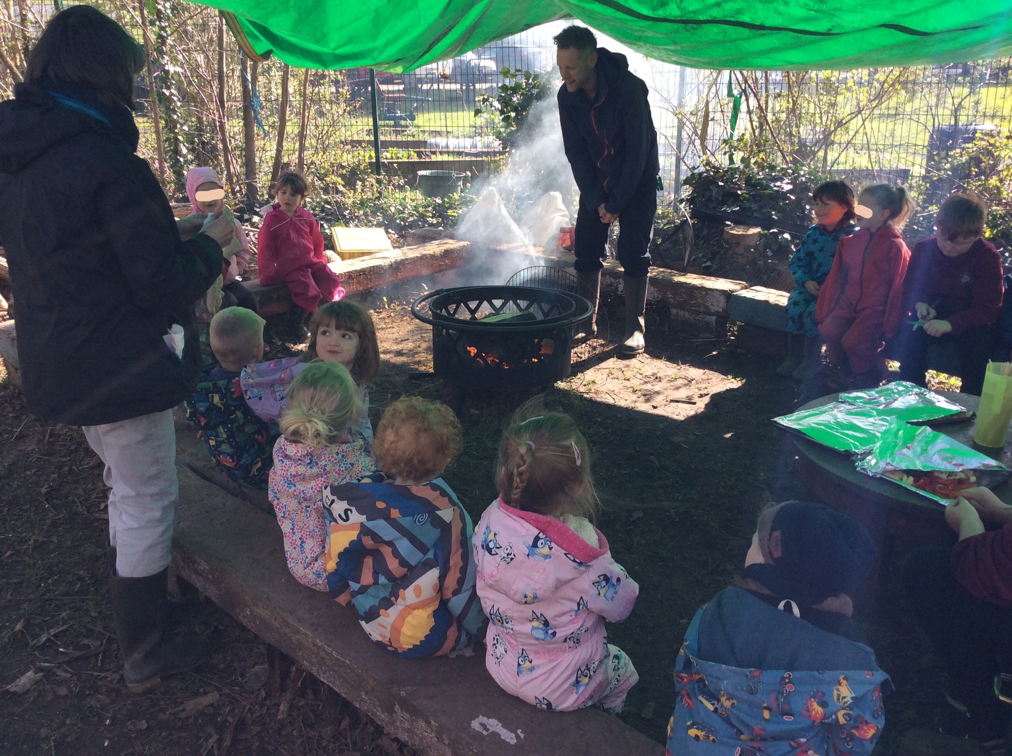 Children gathered around a campfire during a Forest School session