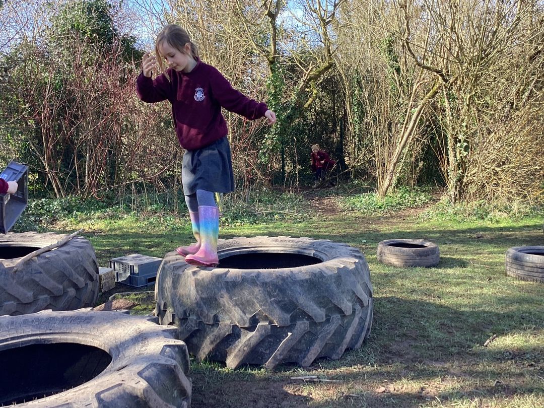 Child balancing on tyres in the outdoor adventure area