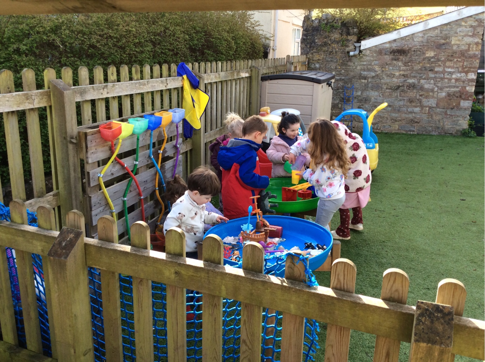 Little Acorns children playing with water outdoors