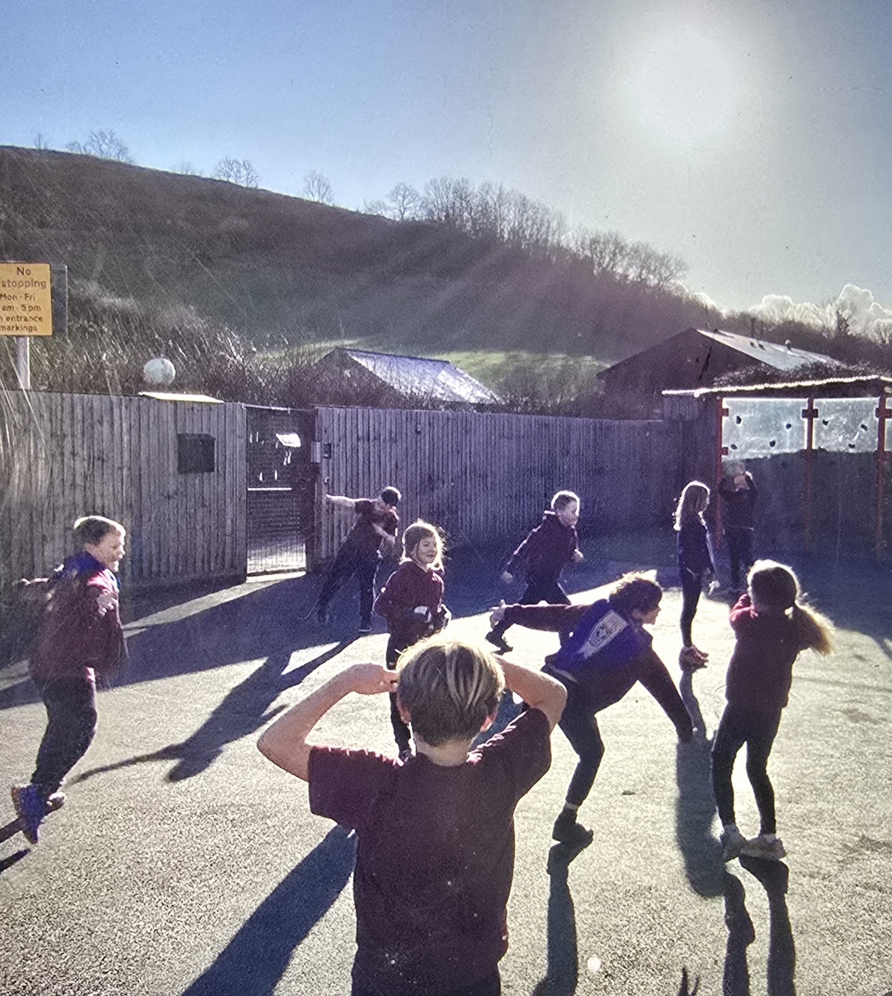 Children playing together on the playground with Somerset hills in the background.