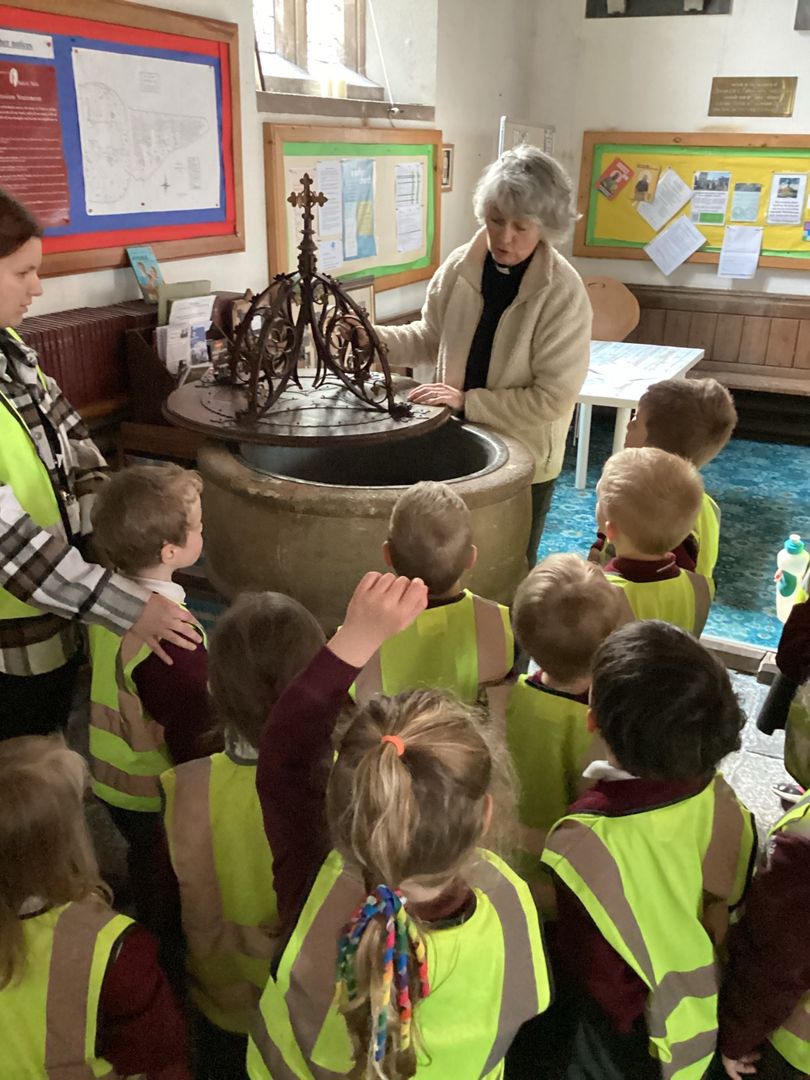 Children with a vicar at a font