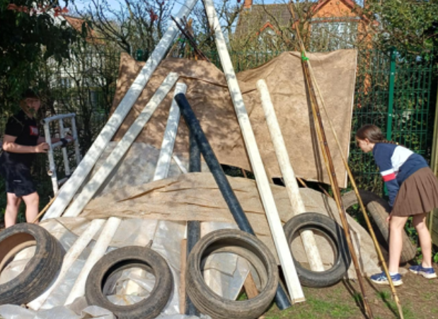 Children building a den with tarp and tyres
